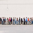 A line of people waiting to get inside a building.